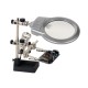 Derde hand met vergrootglas en lamp